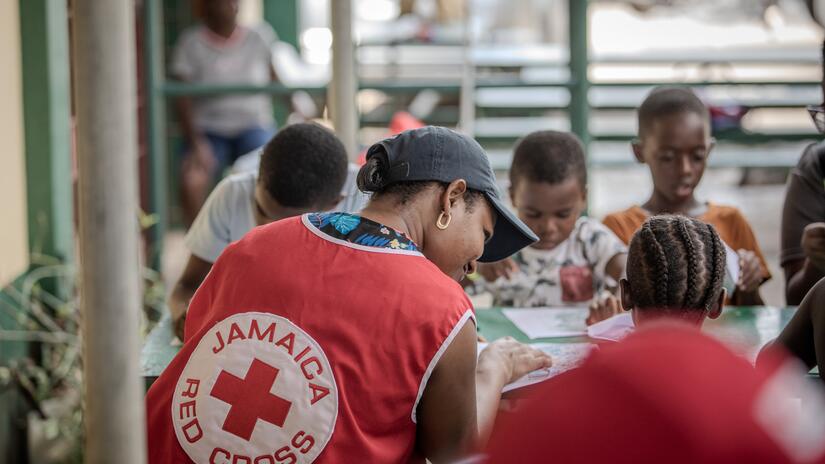 A Jamaica Red Cross volunteer provides psychosocial support to children affected by Hurricane Melissa.