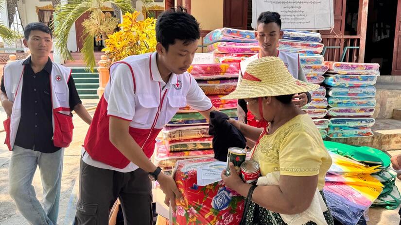 A Myanmar Red Cross volunteer providing food and household items to people who lost their homes and all belongings  due to the earthquake.