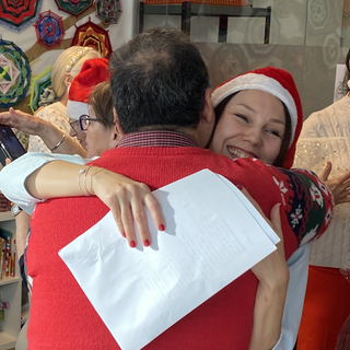 Johnny Bizot (left), a volunteer at the Geneva Red Cross Refugee Welcome Day Center, gives a hug to a member of the choir he directs at the centre. 