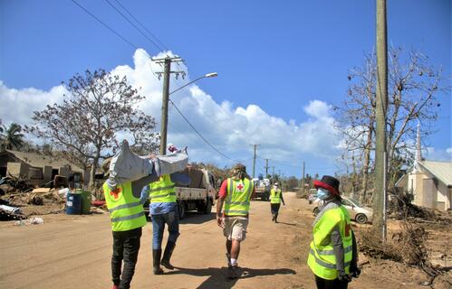 Tonga Red Cross Society volunteers carry shelter equipment to set up temporary housing for people affected by the Hunga Tonga Hunga Ha’api volcanic eruption and tsunami in January 2022.