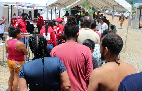 People on the move gather at San Vicente Station, Panama in July 2022 as they move northwards in search of a better life. The Panamanian Red Cross is providing a wide range of humanitarian services to people on their journeys.