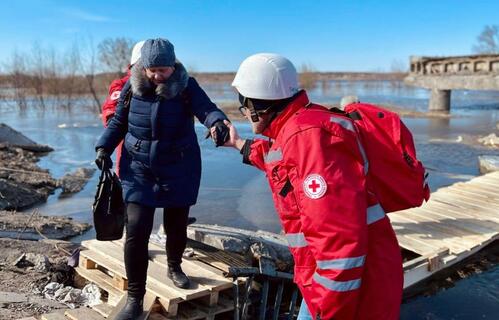 After a bridge to Demydiv, Ukraine was damaged in hostilities in April 2022, Ukrainian Red Cross emergency response team volunteers built a crossing over the river and helped evacuate more than 15,000 people.