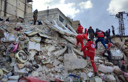 Syrian Arab Red Crescent volunteers rush to rescue people trapped under collapsed buildings in Lattakia following devastating earthquakes on 6 February 2023.