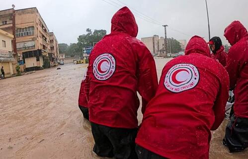 A team of Libyan Red Crescent volunteers wade through flood waters caused by Storm Daniel in September 2023 to reach affected communities.