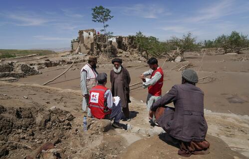Afghan Red Crescent volunteers meet with people impacted by recent floods.