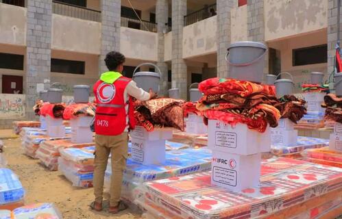 A Yemen Red Crescent volunteer stacks up household supplies that will be given to people who lost their homes due to severe and sudden flooding.