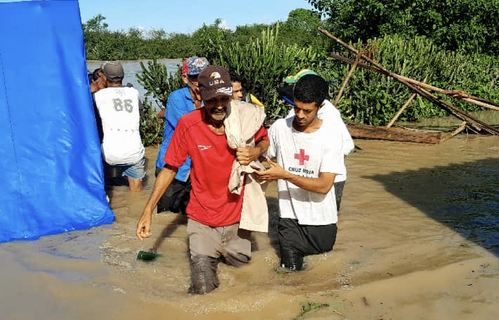 A volunteer helps a man through floodwaters following Hurricane Melissa's arrival in Cuba.