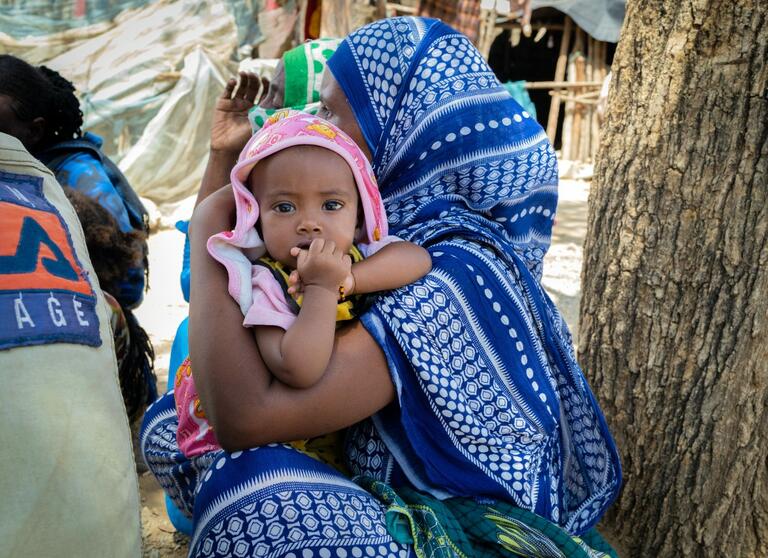 A mother holds her daughter in a camp for internally-displaced persons in Koneba, Ethiopia 