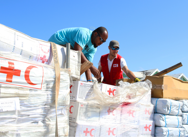 Red Cross delegates unload relief items during a distribution at Marsh Harbour port, the Bahamas following Hurricane Dorian