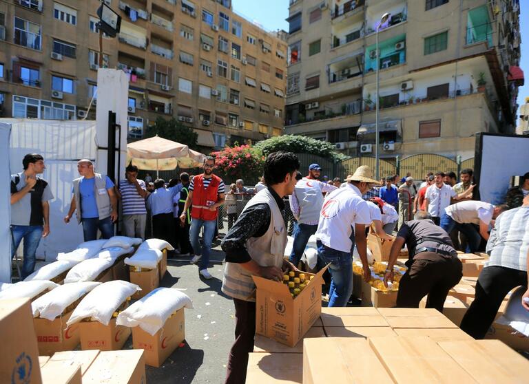 Syrian Arab Red Crescent volunteers distribute relief supplies to communities in 2013