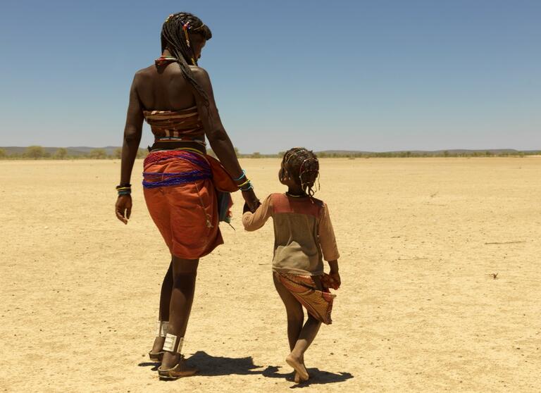 Mbeungua, 47, and her 6-year-old daughter walk to Oukongo village in Namibia where many Angolan refugees have relocated due to a harsh drought affecting their homeland