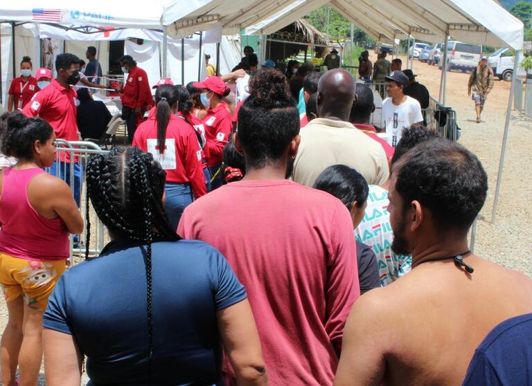 People on the move gather at San Vicente Station, Panama in July 2022 as they move northwards in search of a better life. The Panamanian Red Cross is providing a wide range of humanitarian services to people on their journeys.