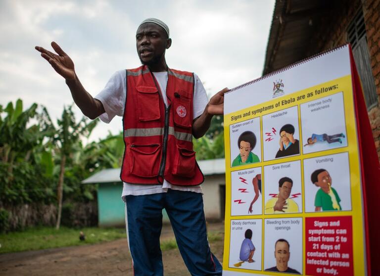 A Ugandan Red Cross volunteer speaks to communities about how to stay safe from the Ebola virus disease - responding to people's concerns and questions.