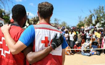 A Mozambique Red Cross volunteer hugs an IFRC staff member as they distribute emergency supplies to thousands of people in Buzi district affected by Cyclone Idai in 2019