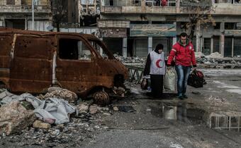 Volunteers with the Syrian Arab Red Crescent walk through a humanitarian passage in Boustan al Qasar, Aleppo