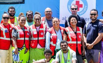Members of the Fiji Red Cross and IFRC stand together in Kilaka village where they supported more than 2,500 people affected by Cyclone Yasa in December 2020