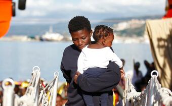 A woman carries her child aboard Mediterranean search and rescue vessel Responder in October 2016. International Red Cross teams worked tirelessly to provide people rescued at sea with medical support, blankets, food and water.