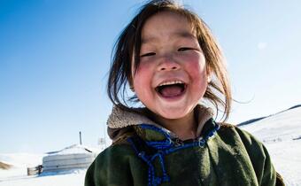 A young daughter from a family of herders in Khuvsgul province, northern Mongolia smiles at the camera. Her family received food, warm clothes and cash assistance to help them cope with the recent dzud (a severe winter)