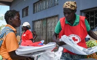 A Mozambique Red Cross volunteer hands out essential relief items to communities in Buzi who were affected by Cyclone Idai