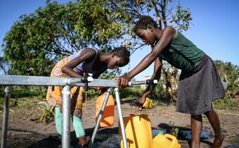 Children in Mozambique test the first drops of water from a new water point installed by the Spanish Red Cross following Cyclone Idai in
