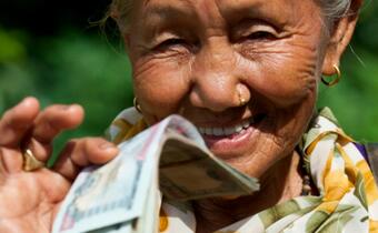 A woman receives a cash grant of 15,000 rupees from the Nepal Red Cross, Danish Red Cross and British Red Cross following the earthquake in April 2015