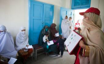 A Pakistan Red Crescent volunteer leads a hygiene lesson with women waiting to see a doctor at a health clinic in the north of the country