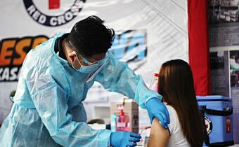 A volunteer from the Philippine Red Cross administers a COVID-19 vaccine in March 2021 in support of the government's country-wide vaccination programme