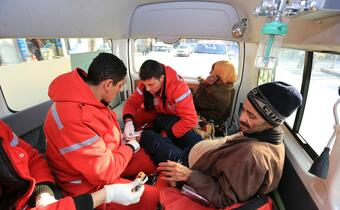 First aid squads from the Syrian Arab Red Crescent and the Palestinian Red Crescent perform a medical check-up on a man who lost his leg due to diabetes