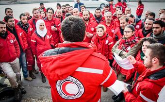 A large group of Syrian Arab Red Crescent volunteers is briefed before they travel to provide essential assistance to besieged communities in Madaya, Kafriya and Fouaa in January 2016
