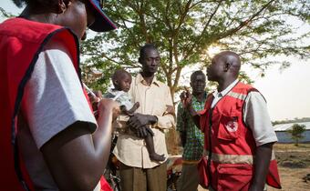 Ugandan Red Cross volunteers speak to a family from South Sudan seeking refuge in Dzaipi Refugee Camp, Uganda
