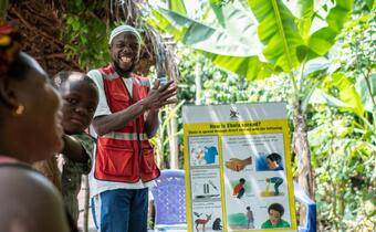 A Ugandan Red Cross volunteer teaches his local community how to recognise signs of the ebola virus so they can alert local health authorities to take rapid action