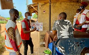 Guinea Red Cross volunteers speak to members of their community about how to prevent and recognise symptoms of Ebola