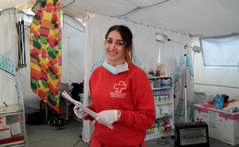A volunteer with the Hellenic Red Cross provides support to migrants on the border with Macedonia