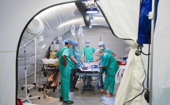 A Finnish and Norwegian Red Cross Emergency Response Unit team performs an operation on a baby boy in a field hospital in Kutupalong refugee camp, Bangladesh 