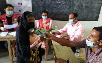 Bangladesh Red Crescent Society volunteers in Jamalpur distribute cash payments to communities in advance of predicted floods based on forecast information to help them cope and minimise any impact on their lives and livelihoods