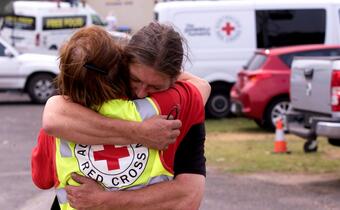 An Australian Red Cross Volunteer hugs and provides psychosocial support to a man who lost his home during the bushfires in Victoria, Australia in December 2019