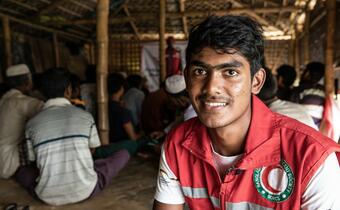 A youth volunteer with the Bangladesh Red Crescent Society provides training in Cox's Bazar refugee camp on the IFRC's participatory approach to safe shelter and settlements awareness (PASSA)
