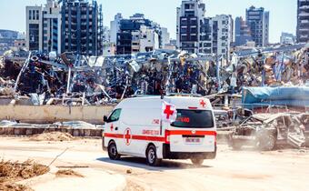 A Lebanese Red Cross response vehicle drives among damaged buildings and rubble following the massive port explosion in Beirut in August 2020