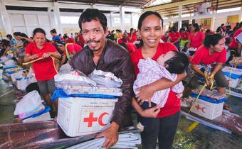 A family in Surigao city, Philippines smile as they receive relief supplies from the Philippine Red Cross following the 2017 Surigao earthquake