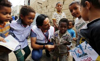A Yemen Red Crescent volunteer teaches a group of children about washing their hands properly before and after eating to help prevent cholera infection