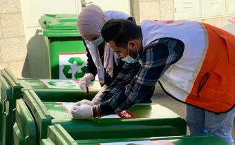 Palestine Red Crescent Society youth volunteers set up recycling facilities to maintain sanitation in public areas and raise awareness of environmentally friendly behaviours