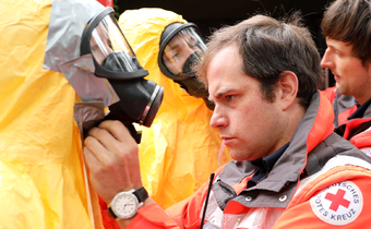 German Red Cross volunteers put on personal protective equipment to respond to a biological hazard