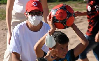 A volunteer from the Argentinian Red Cross leads children in a game of football as part of the IFRC's 'Uniting through the power of football' project in partnership with Generation Amazing
