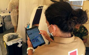 A Portuguese Red Cross volunteer uses an iPad to manage data about COVID-19 testing in the community
