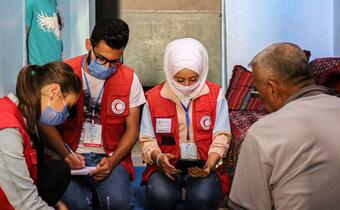 Syrian Arab Red Crescent staff speak to a family in their home in Aleppo to see how food aid and other relief assistance is helping them.