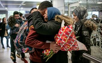 A family hugs one another as they reunite in France, having been supported by the French Red Cross.