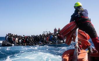 SOS MEDITERRANEE rescue teams approach an overcrowded rubber boat in the Mediterranean in late March 2022. Teams brought people aboard the Ocean Viking ship as part of a 5-hour rescue operation during dangerous weather conditions. Two people had tragically lost their lives aboard the dinghy.