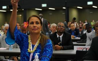 A representative from the Cook Islands Red Cross Society lifts her country placard as part of the roll call at the 23rd session of the IFRC General Assembly in Geneva, June 2022