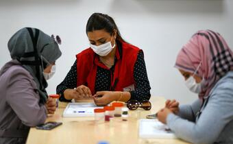 A Turkish Red Crescent employee teaches jewellery-making techniques to Syrian women in a community centre in Ankara to help them learn a new livelihood.