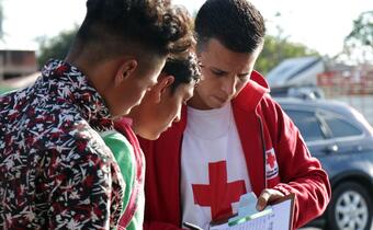 A Guatemala Red Cross volunteer speaks to two young men on the move as they make their way northwards through Central America in search of a better life.